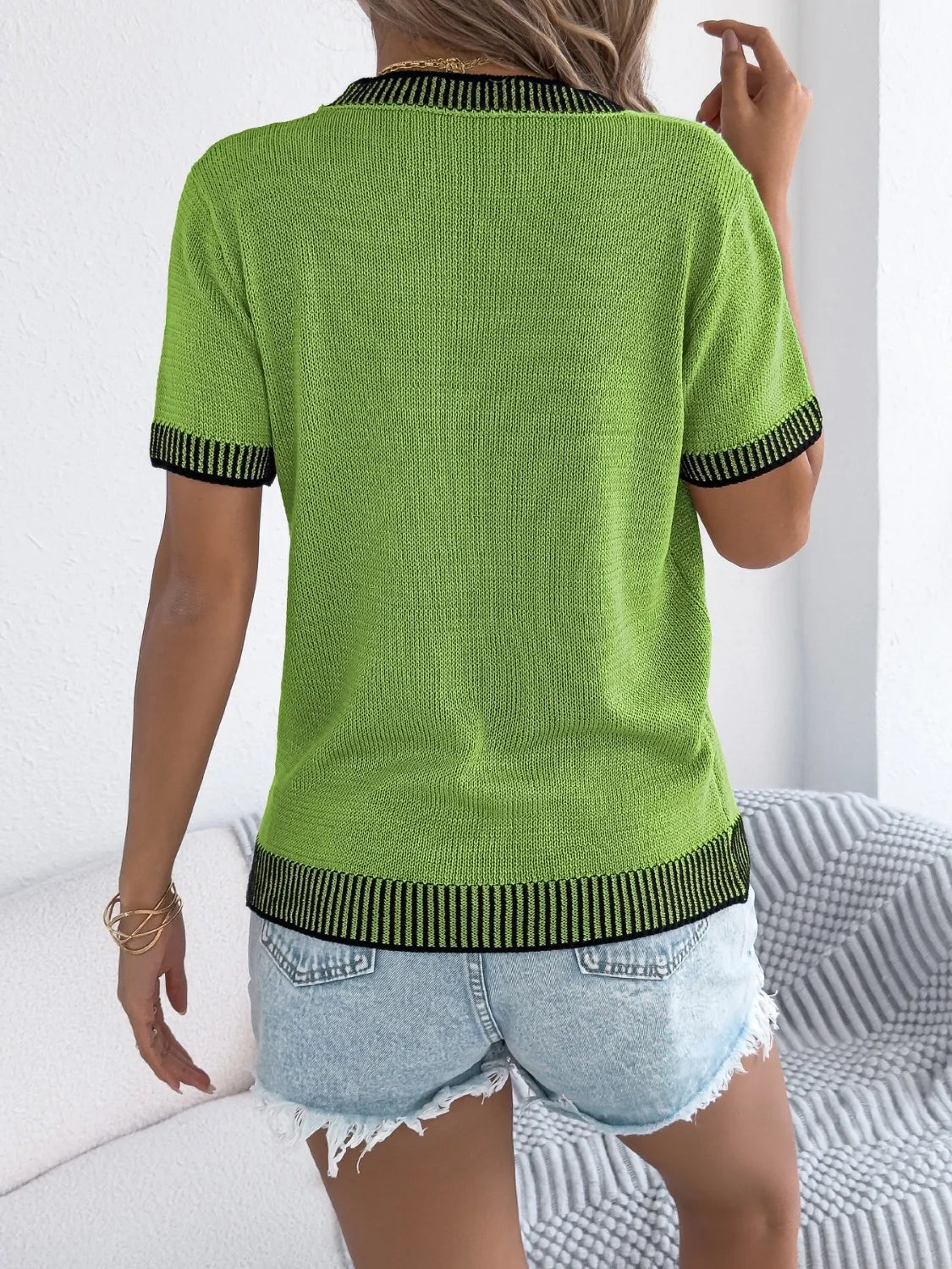 Green knit tee with contrast trim on collar, sleeves, and hem.