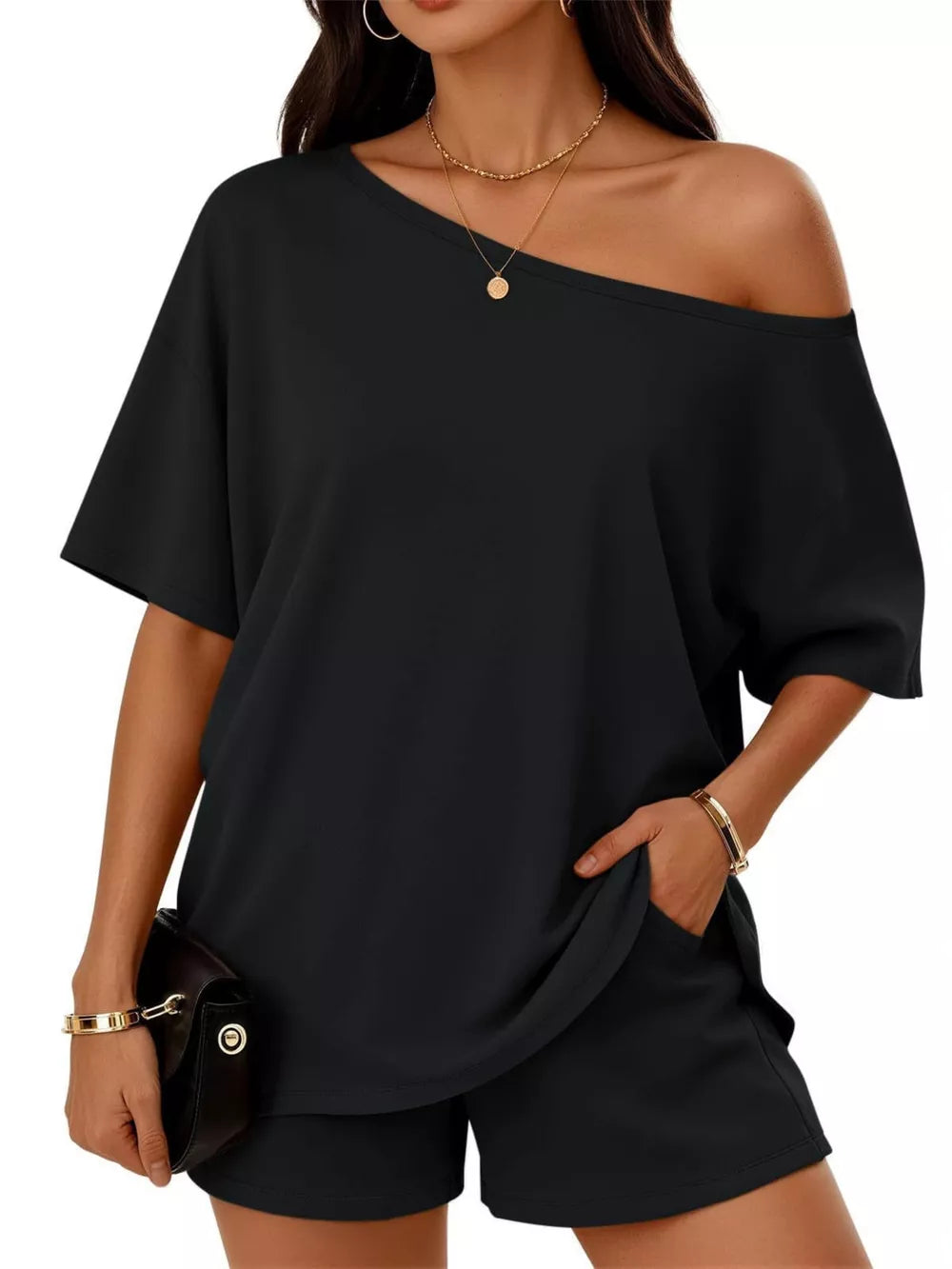 Black asymmetrical one-shoulder top with pockets and matching shorts set.
