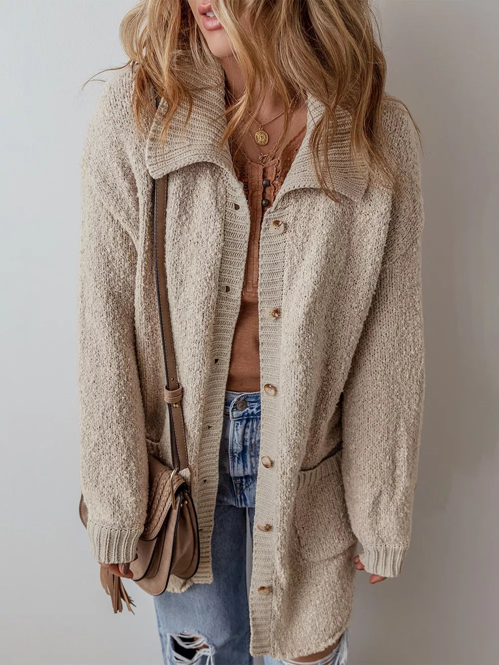 Beige textured button-up cardigan with pockets and a collared neckline.
