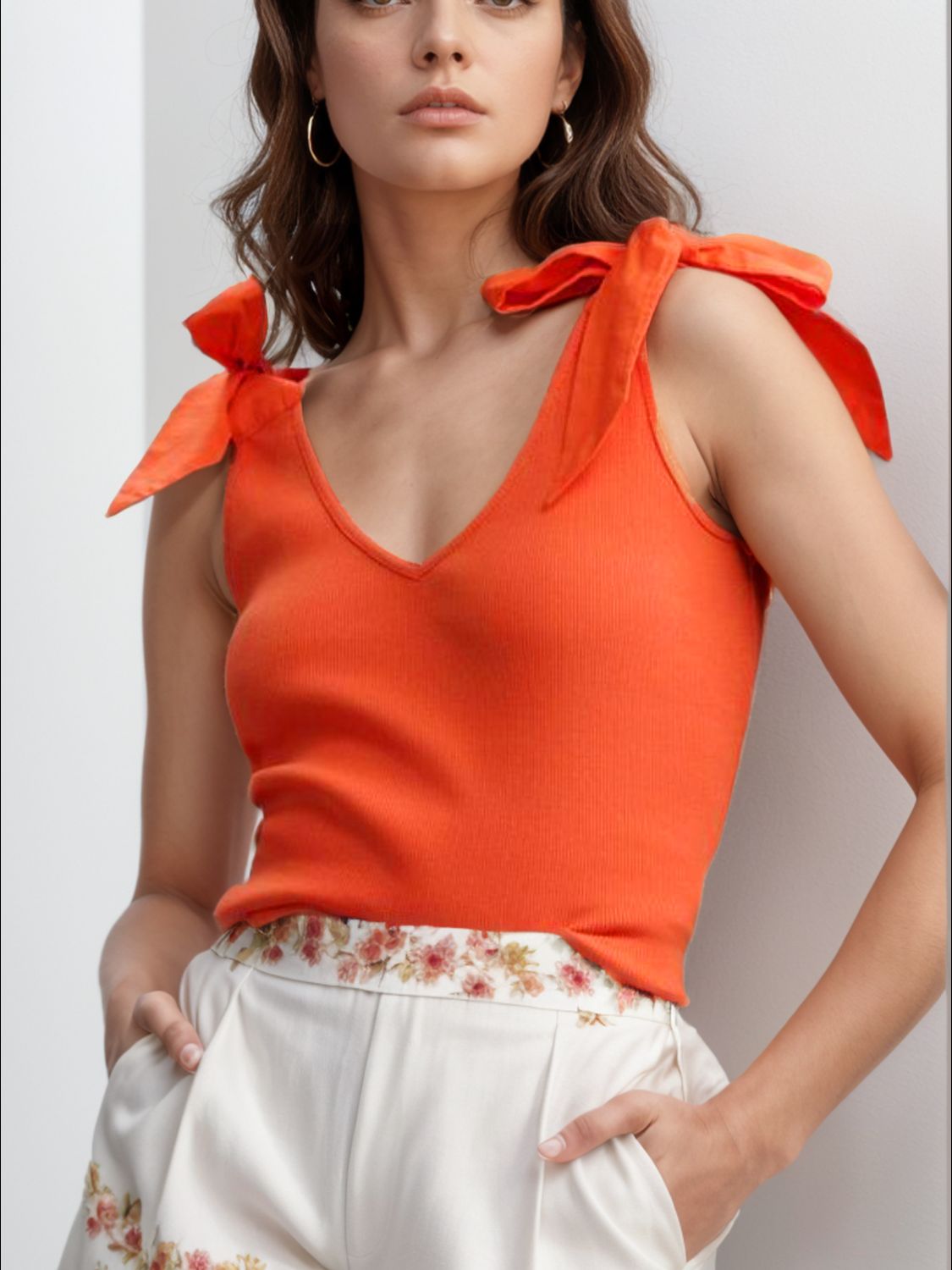 Orange ribbed knit tank top with bow shoulder straps and V-neck