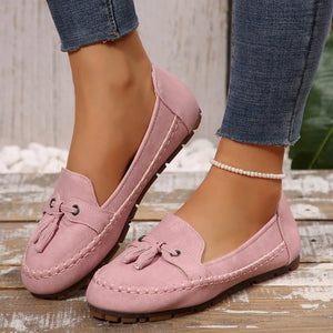 Dusty Pink suede loafer flats with tassel detail and contrast stitching.