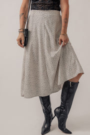Dotted bias-cut midi skirt in heather gray, shown with black boots and a clutch.