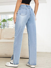 Light wash denim jeans with distressed details and slit hems.