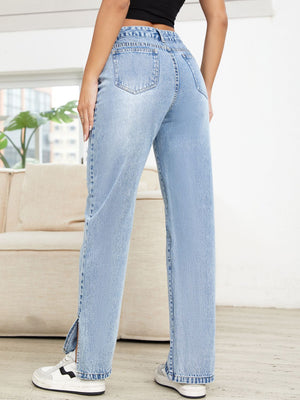 Light wash denim jeans with distressed details and slit hems.