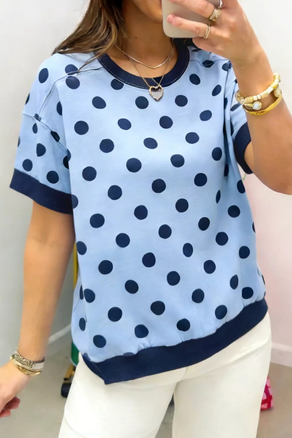 Light blue polka dot knit sweater with navy trim and crew neck.