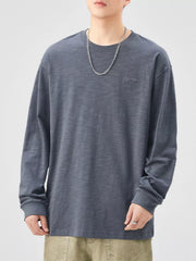 Oversized long-sleeve cotton tee in Space Gray with subtle embroidered logo detail.