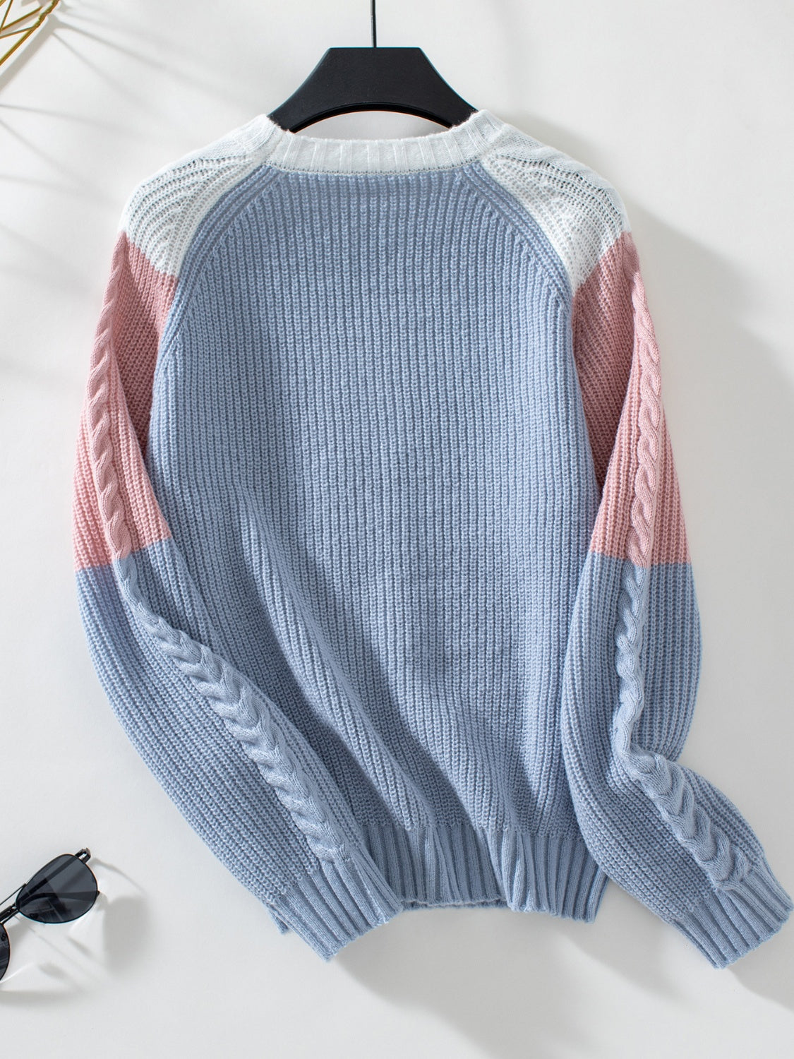 Chevron cable knit sweater in pastel blue, blush pink, and white colorblock with cable knit sleeves.