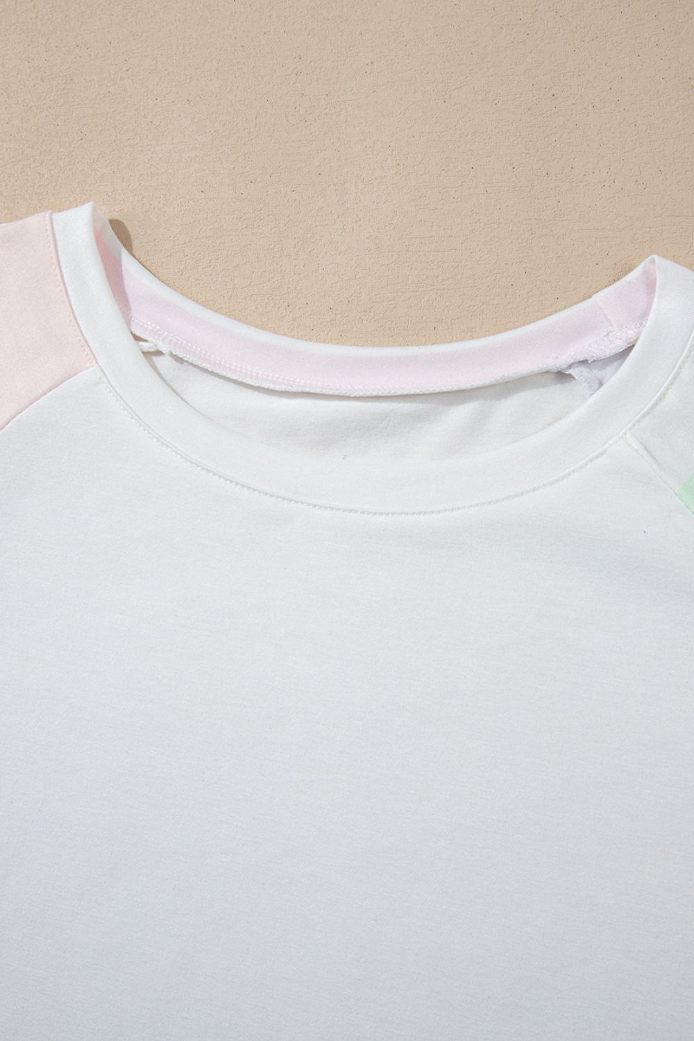 White loungewear set with pink and mint green colorblock sleeves and neckline detail.