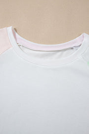 White loungewear set with pink and mint green colorblock sleeves and neckline detail.