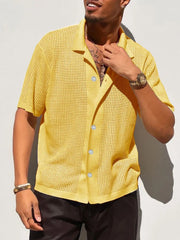 Yellow perforated knit resort shirt with short sleeves and a collared neckline.