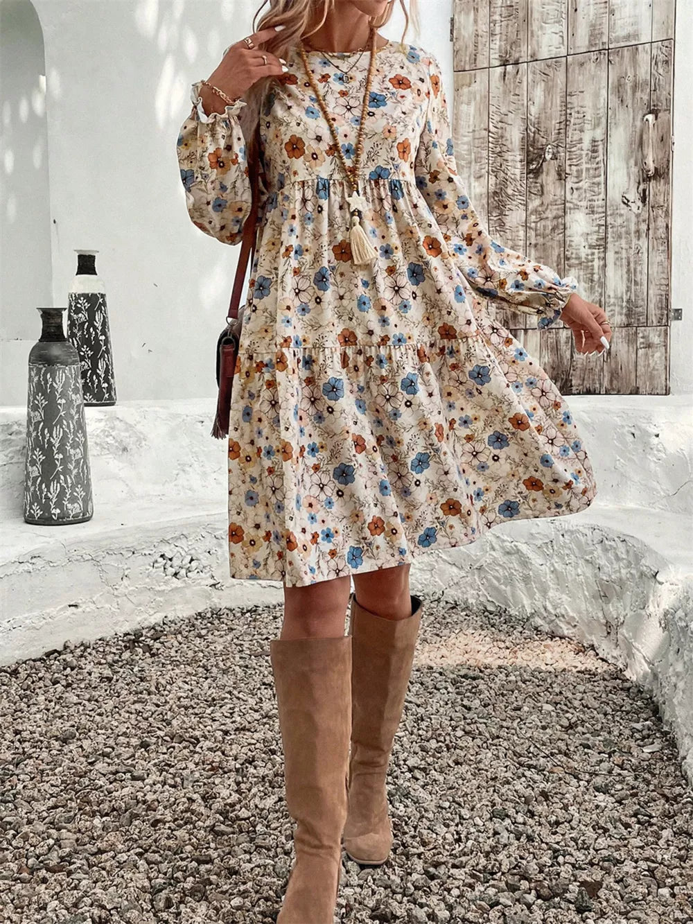 Floral tiered hem long sleeve dress with a cream base and blue, orange, and brown floral print.
