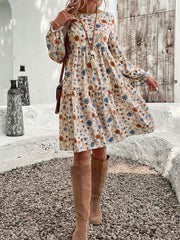 Floral tiered hem long sleeve dress with a cream base and blue, orange, and brown floral print.