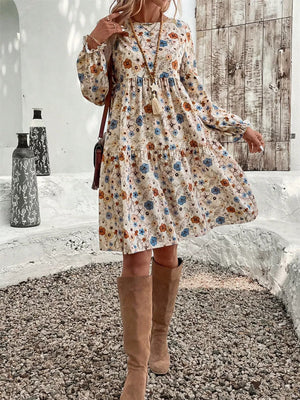 Floral tiered hem long sleeve dress with a cream base and blue, orange, and brown floral print.