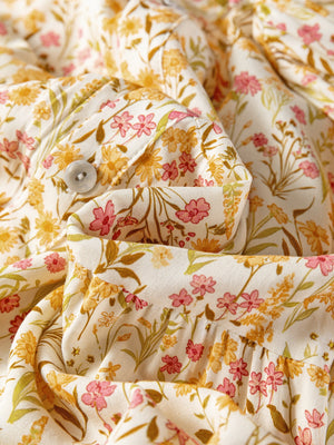 Floral print button-down shirt dress with a loose fit and pink and yellow flowers.