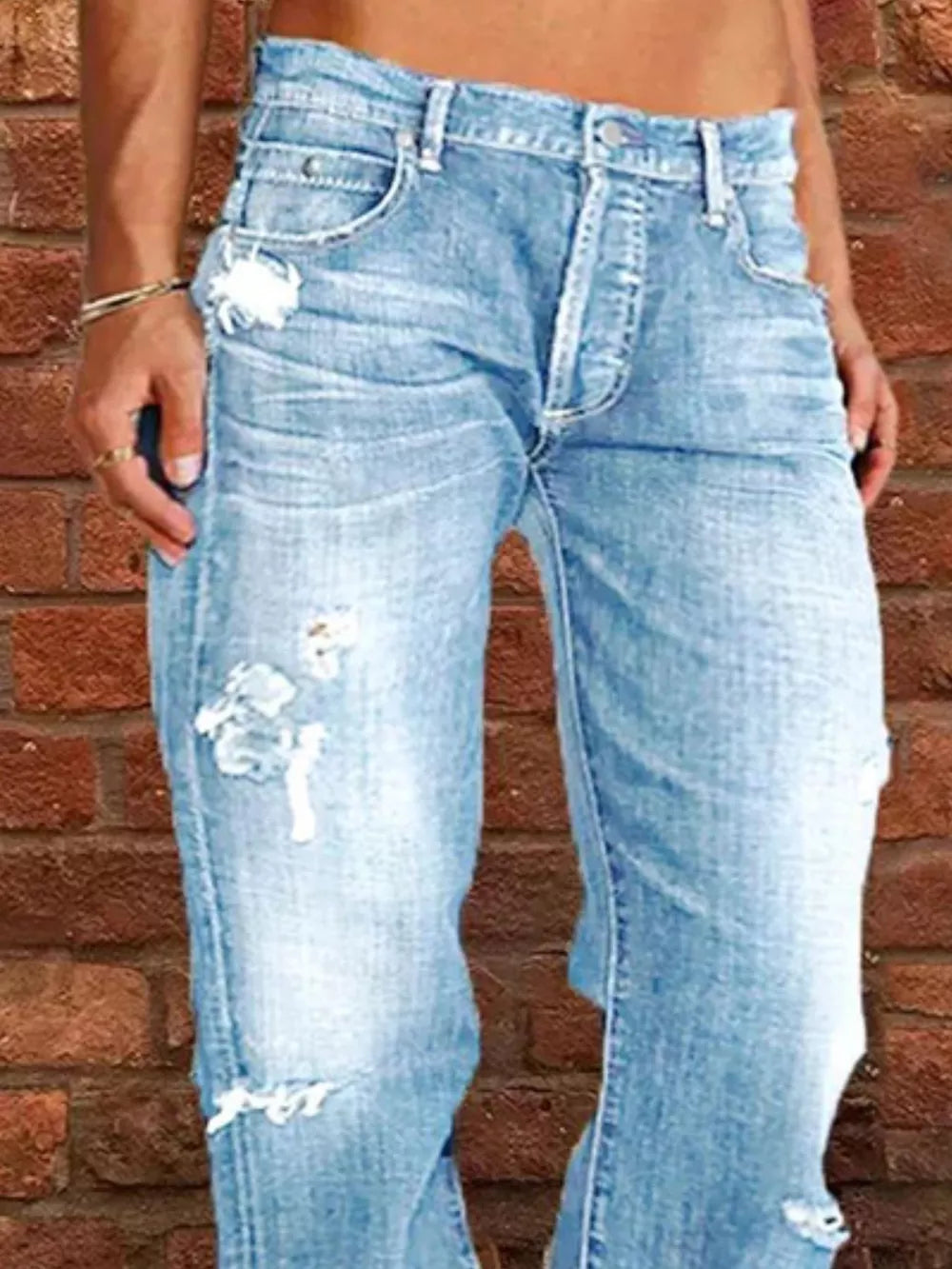 Light blue distressed maternity jeans with raw hem and button fly.