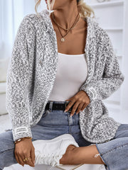 Textured knit zip-up cardigan in charcoal with a subtle geometric pattern and logo detail on the sleeve.