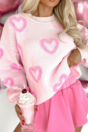 Pink knit sweater with heart appliqué and balloon sleeves.
