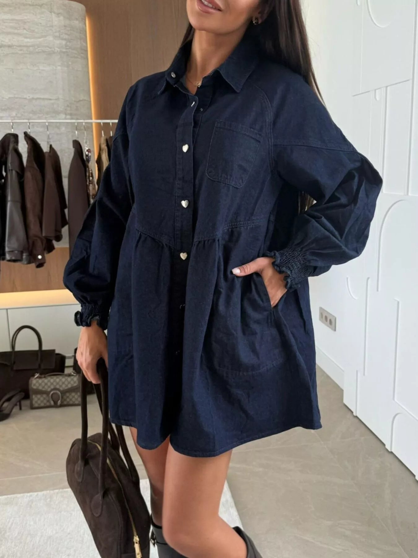 Dark blue denim mini dress with pockets, button front, and smocked cuffs.
