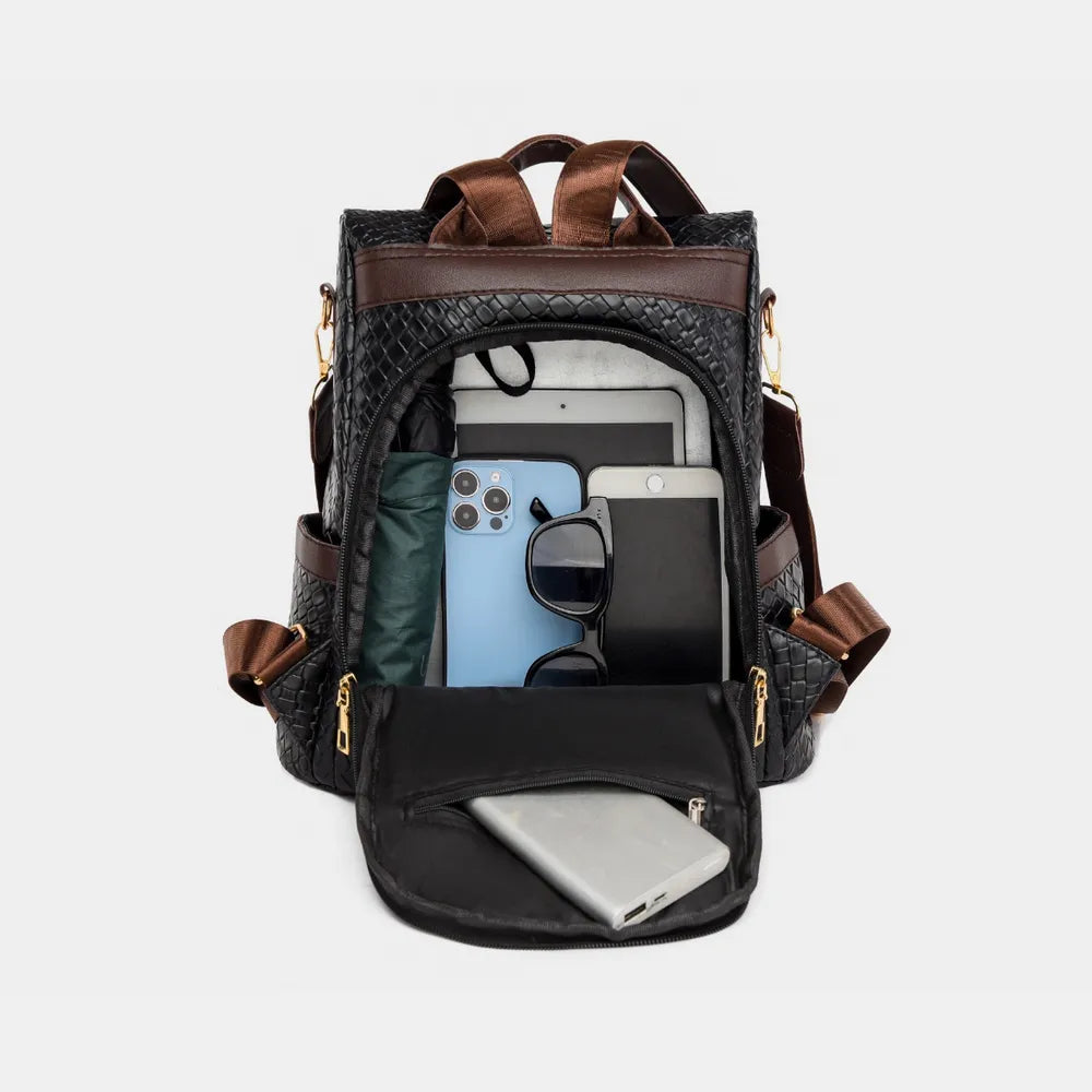Black woven faux leather convertible backpack with brown straps, showing interior organization.