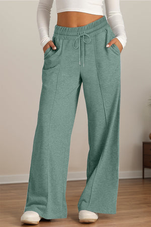 Seamed palazzo lounge trousers in sage green with drawstring waist and pockets.