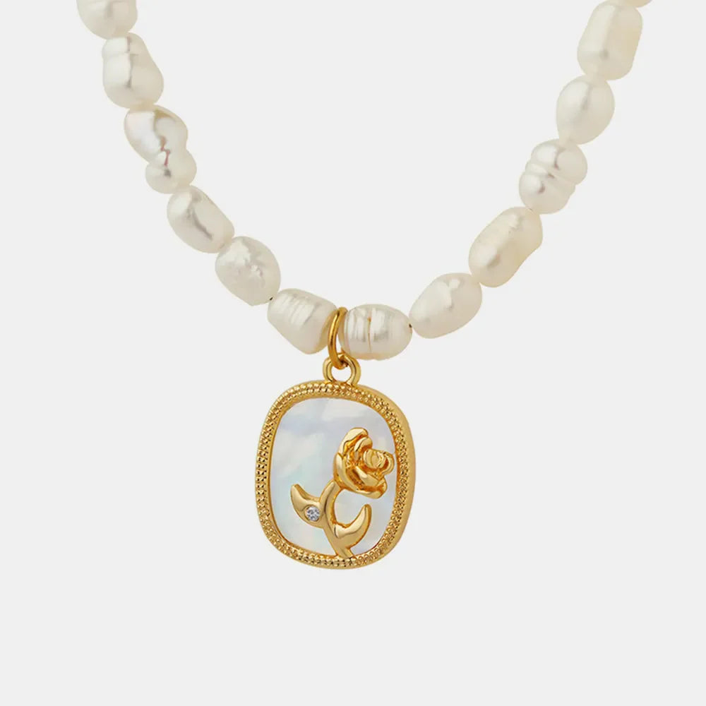 Gold baroque pearl necklace with floral medallion charm and diamond accent