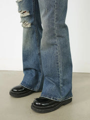Distressed flare leg jeans in medium wash denim with ripped details
