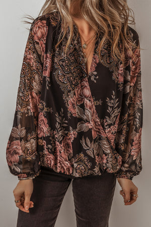 Black floral print surplice blouse with blouson sleeves and a deep V-neckline.