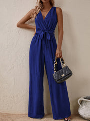 Textured wrap-front wide-leg jumpsuit in indigo with a tie waist and V-neck.