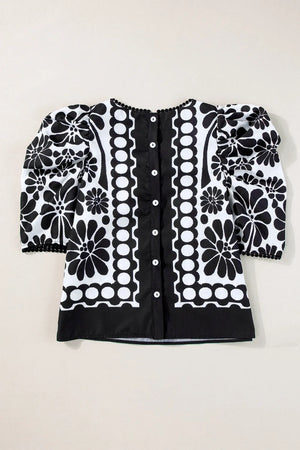 Black floral puff sleeve blouse with button back and decorative trim.