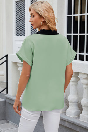 Light Green blouson top with black contrast V-neck and cuffed short sleeves.