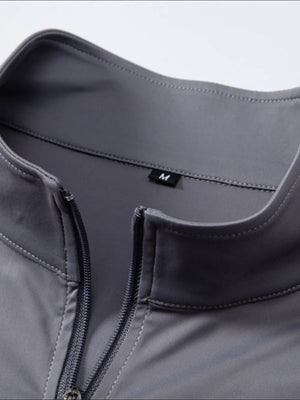 Performance zip-neck tee in dark gray with structured shoulders and a size M tag.