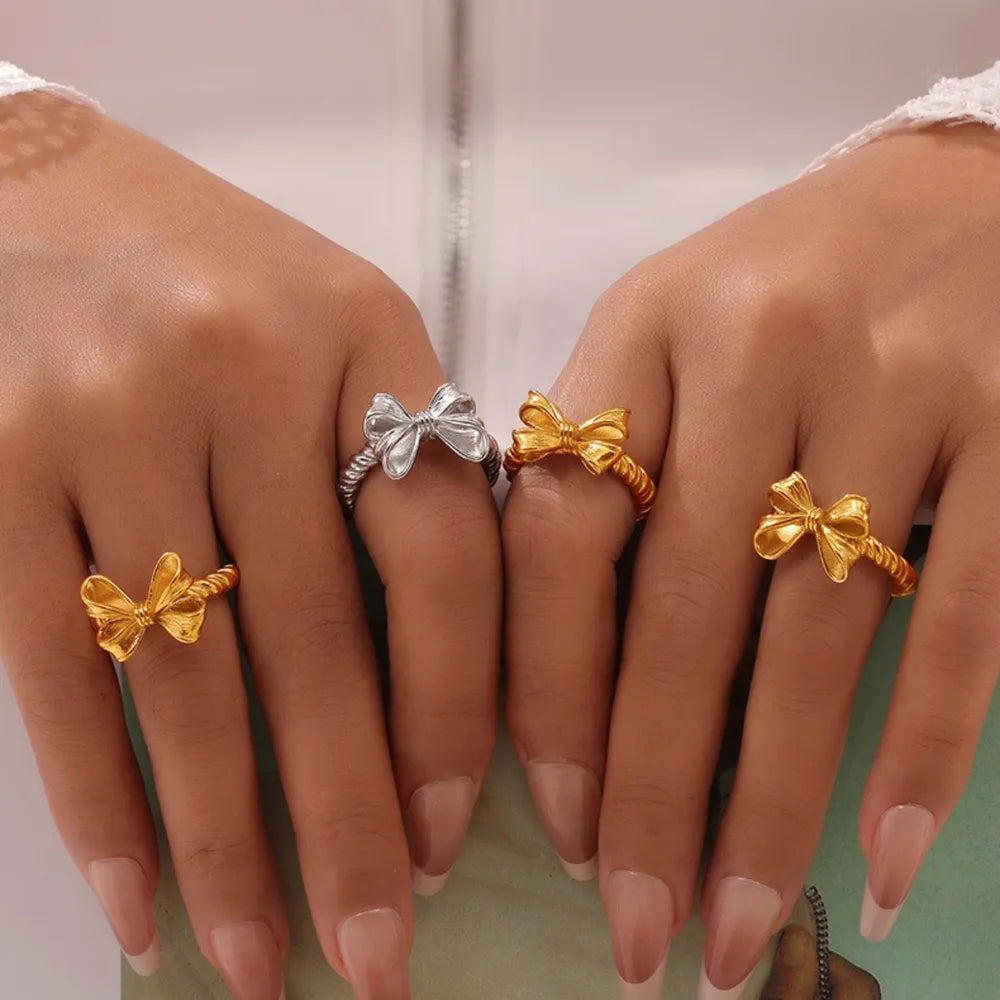 Textured bow knot rings in silver and gold with twisted bands.