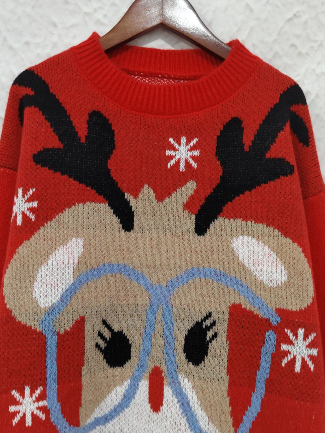 Red acrylic knit sweater with reindeer and snowflake graphic, crew neck.