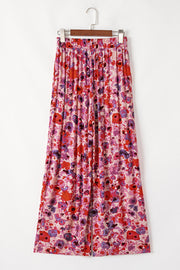 Painterly floral palazzo trousers in strawberry pink with a vibrant, colorful bloom print and wide leg.