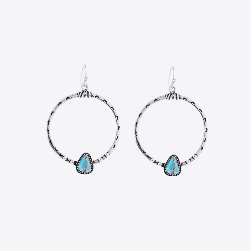 Silver Southwestern hoop earrings with turquoise teardrop stones and beaded details.