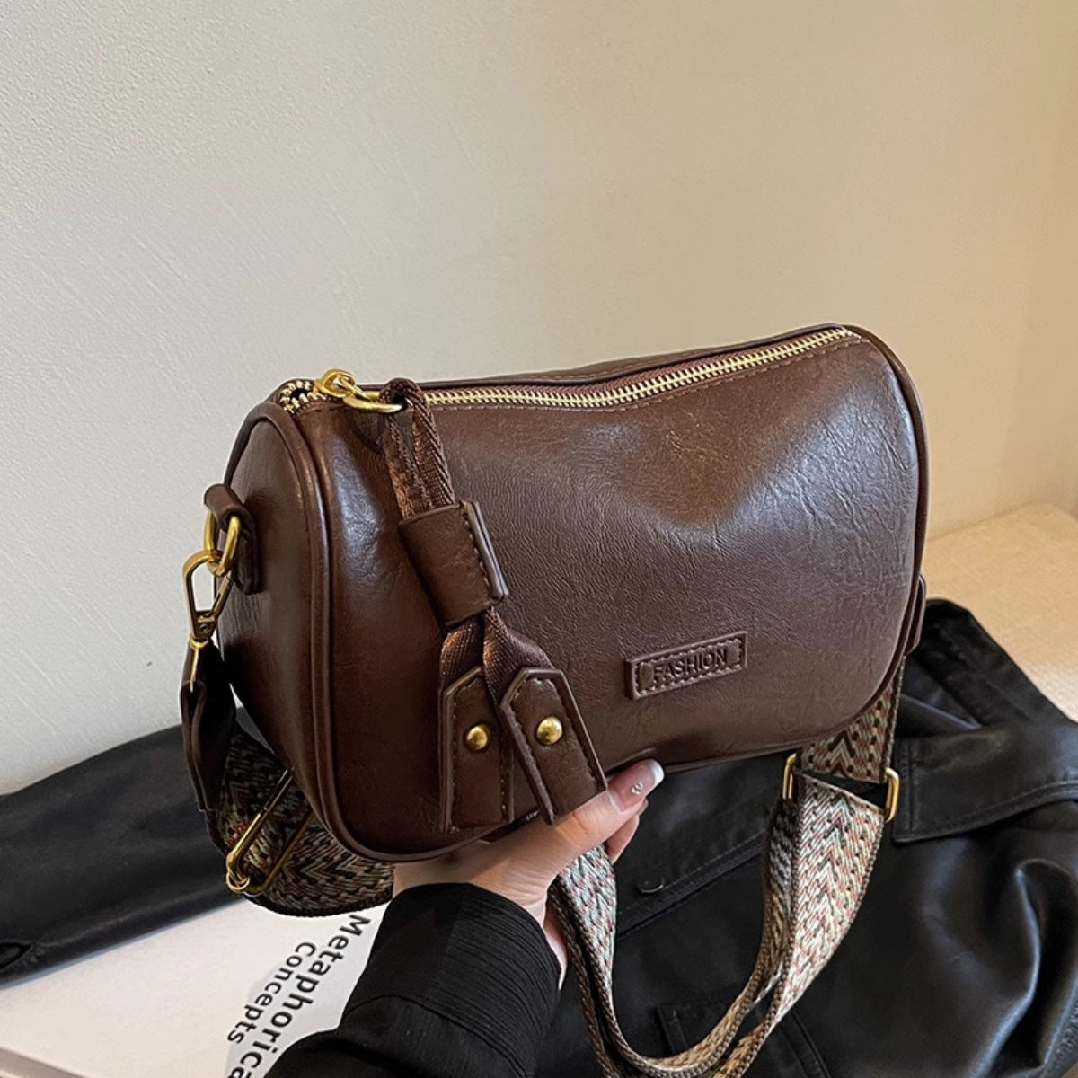 Brown textured pu leather crossbody bag with a patterned strap and gold hardware.