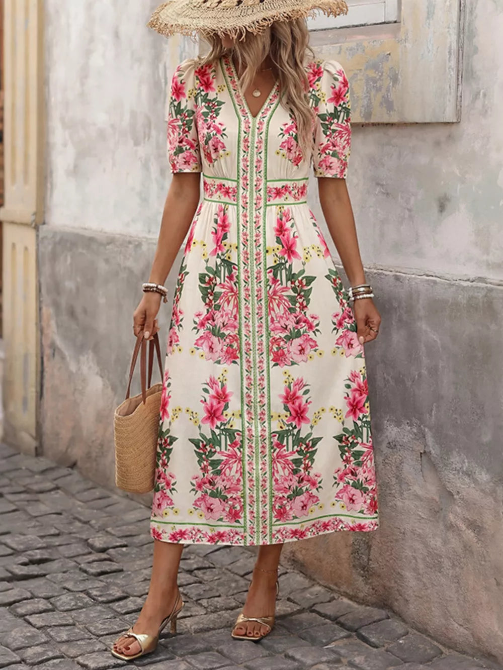 Charming floral v-neck midi dress with short puff sleeves and defined waist, styled with a straw hat.