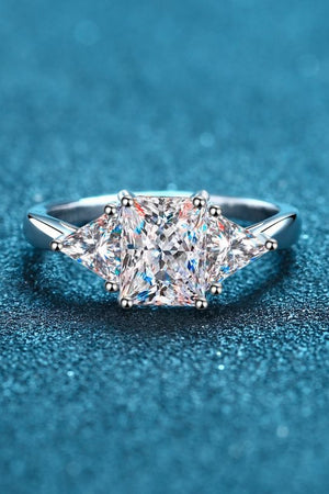Silver trilogy ring with a large princess-cut center stone and two triangle-cut side stones.