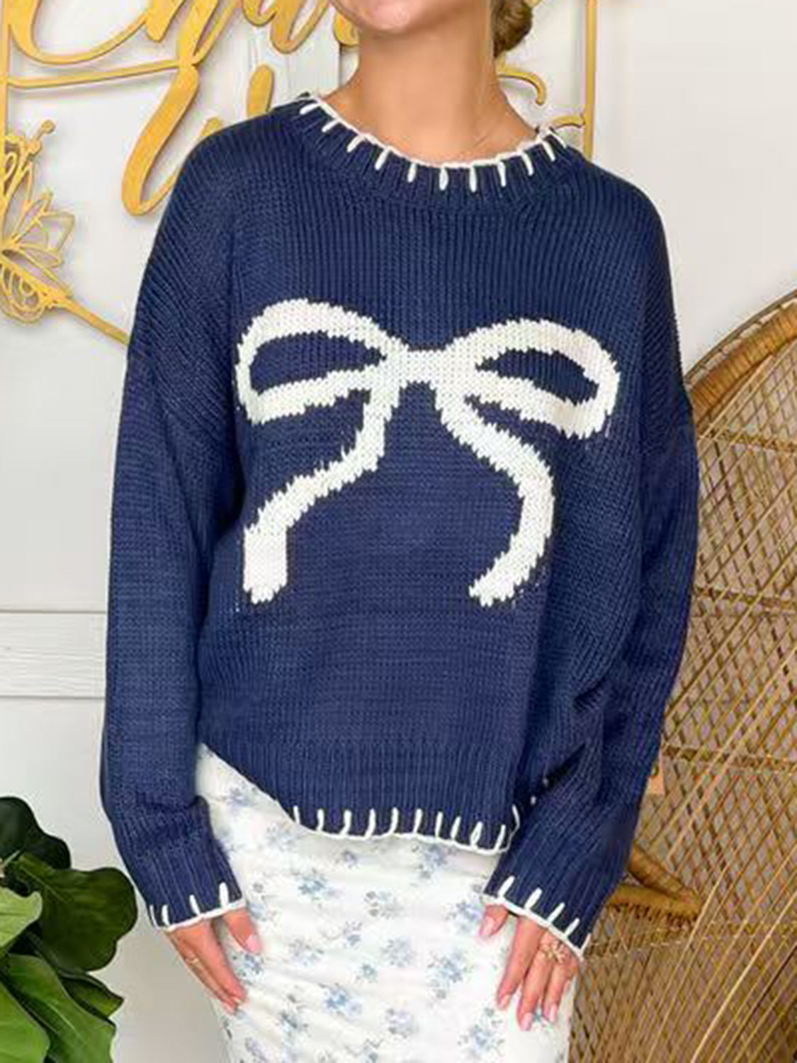 Navy acrylic knit sweater with white bow detail and contrast stitching.