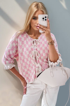 Blush pink and white checkered knit cardigan with tie-front and ruffle sleeves.