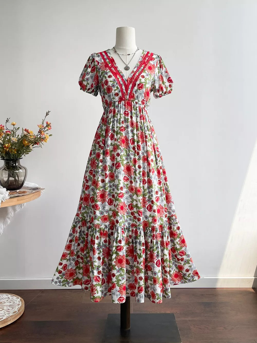Vibrant floral v-neck midi dress with red trim and tiered skirt.
