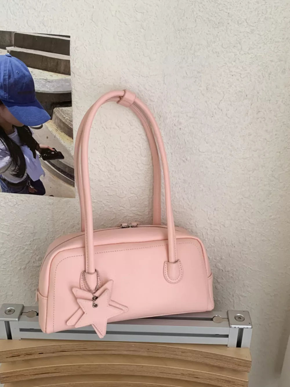 Pink leather shoulder bag with star charm and top handle