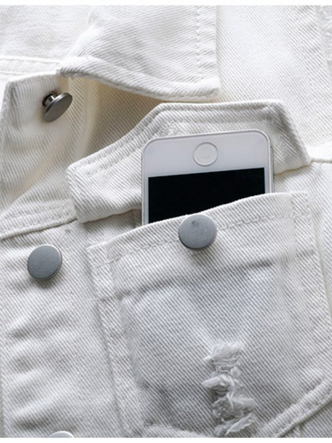 White denim vest with frayed pocket detail and metal buttons, phone in pocket