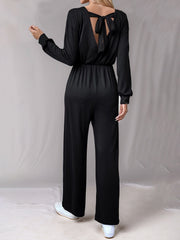 Black wide leg jumpsuit with long sleeves and a back tie detail.