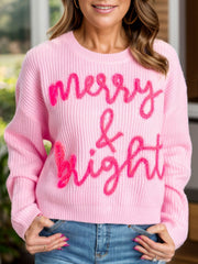 Blush pink knit sweater with embroidered "Merry & Bright" text, crewneck, long sleeves.