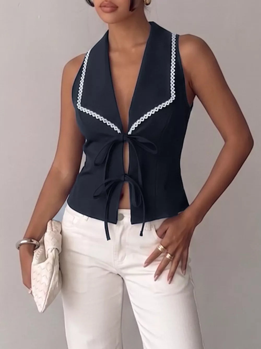 Navy lace-trimmed tie-front vest with a deep V-neck and open front.