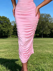 Pink ruched bodycon midi dress with floral appliqué detail.