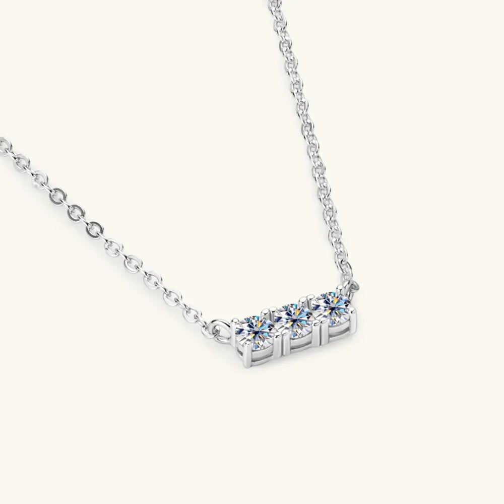 Silver bar necklace with three round moissanite stones.