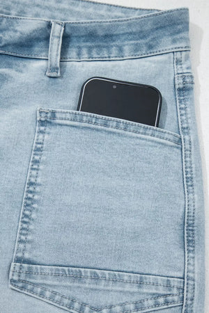 Light wash denim jeans with raw hem and utility pocket detail, showing a phone.