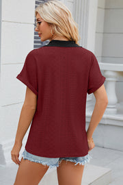 Burgundy perforated polo top with black lace collar and cuffed short sleeves.